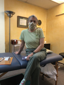 Carol wearing mask sitting in treatment room